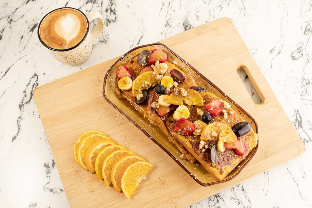 a loaf of bread with fruit and nuts on a cutting board