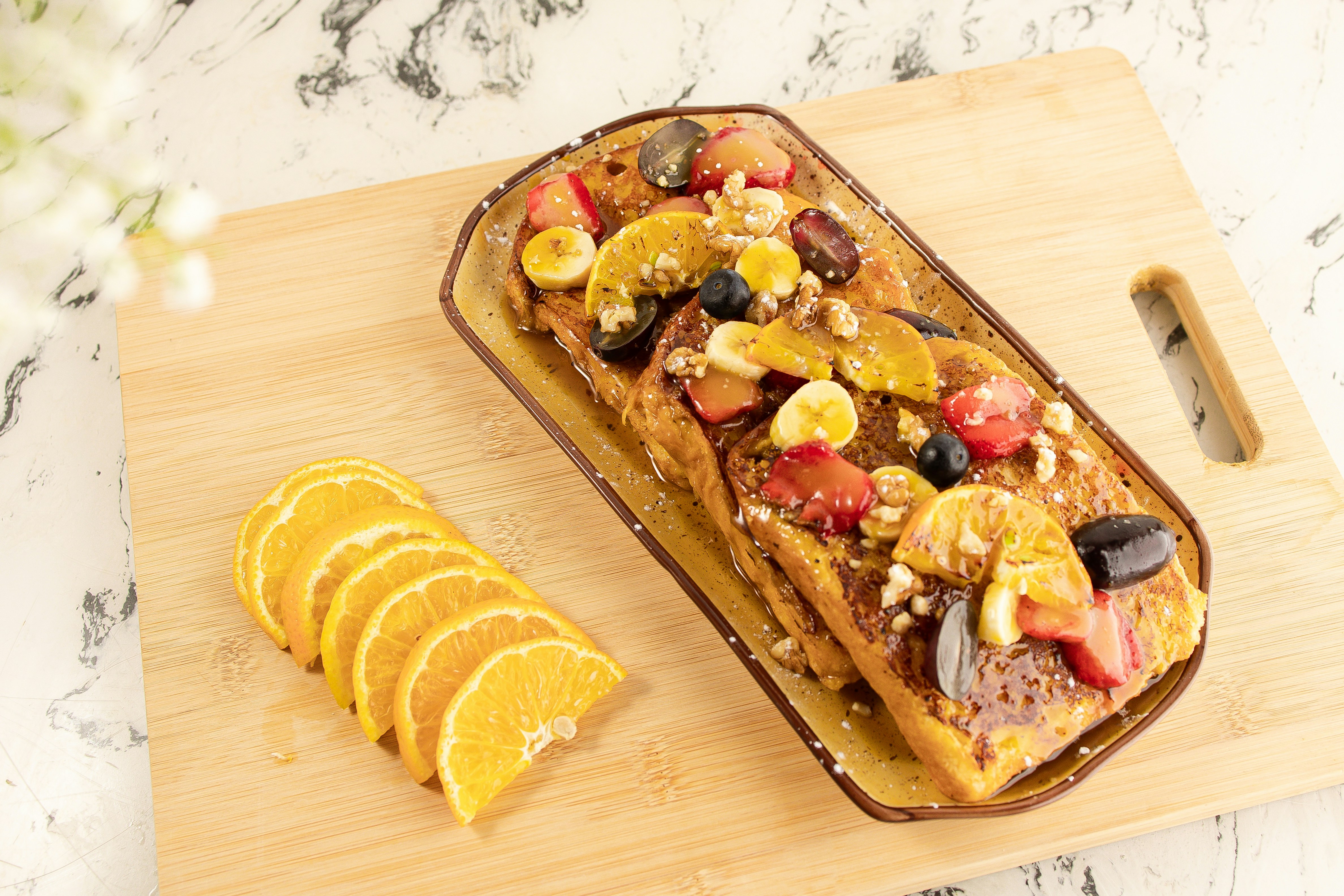 a pan of french toast topped with fruit and nuts