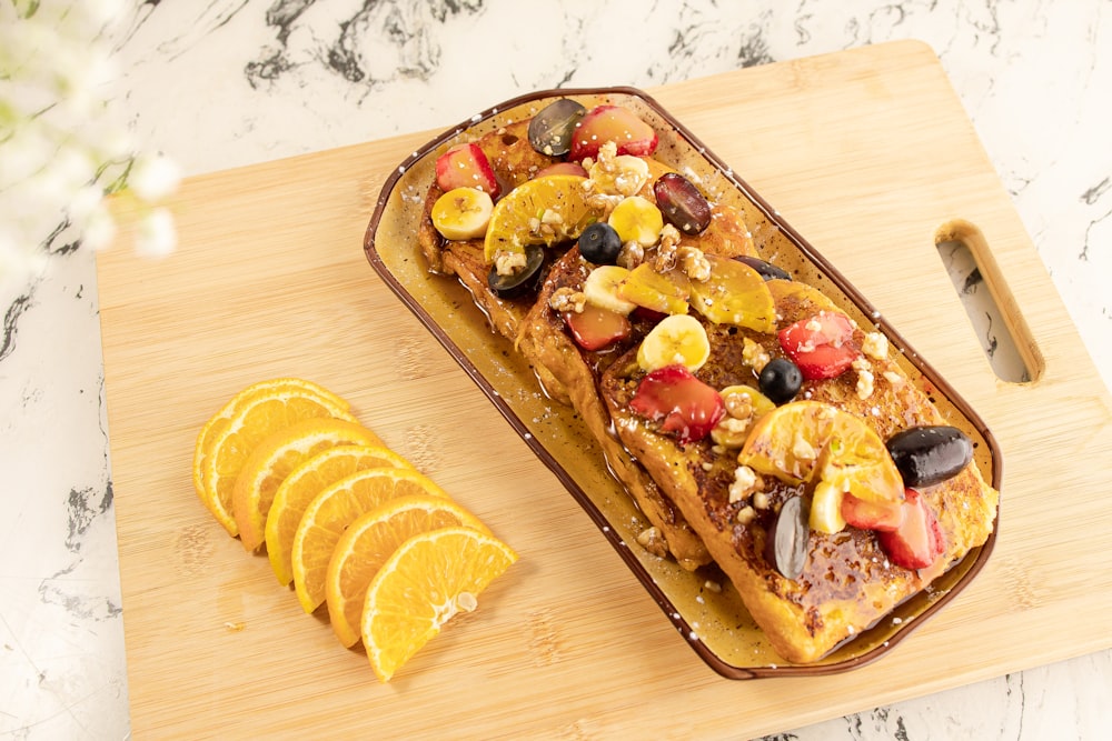 a pan of french toast topped with fruit and nuts