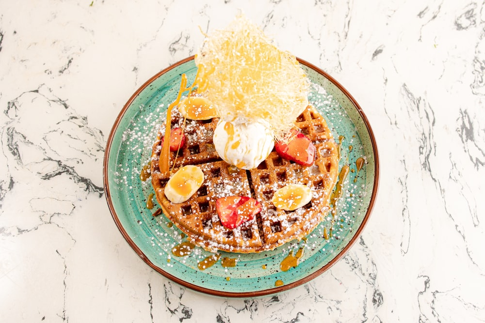 a waffle topped with fruit and powdered sugar