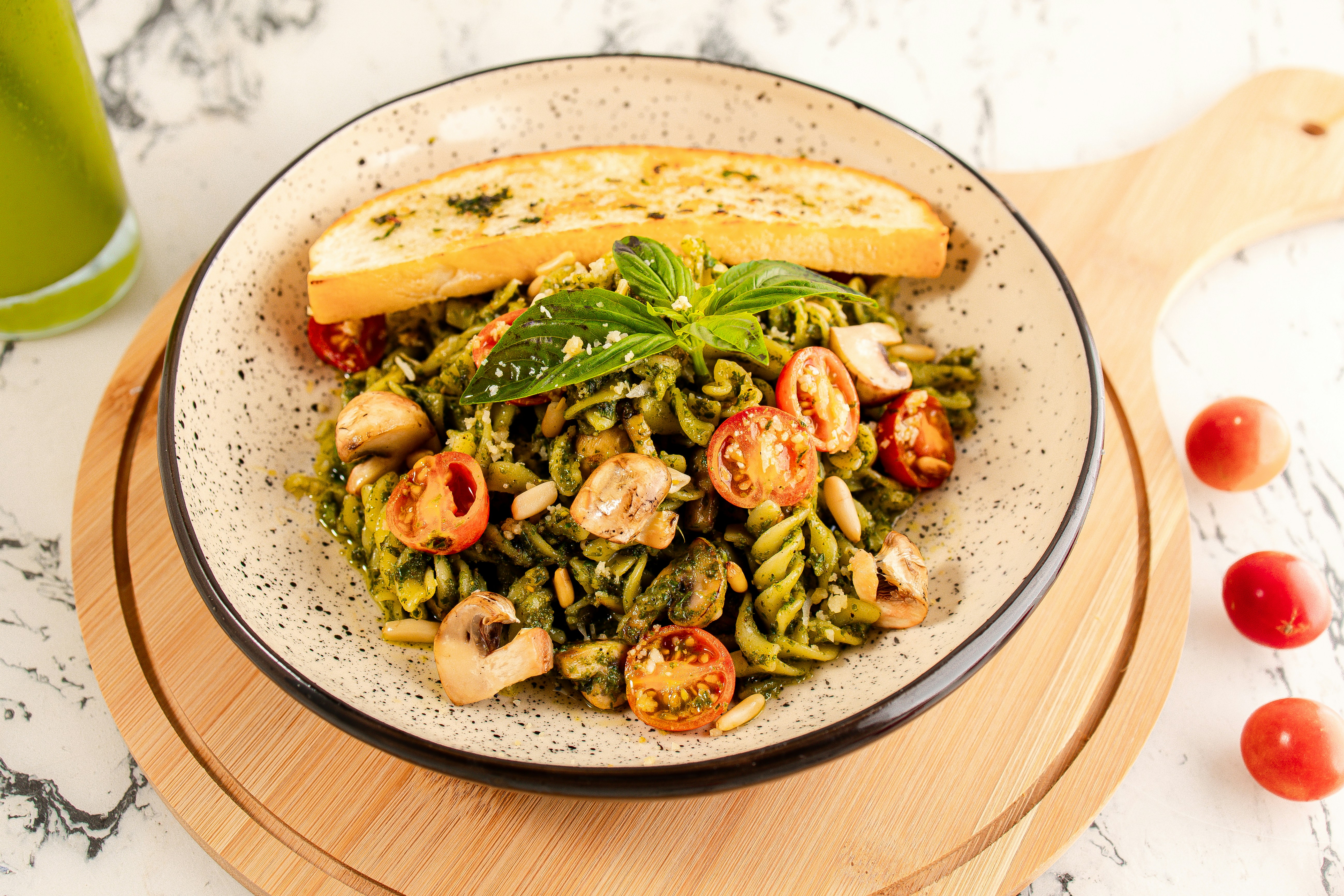 a plate of pasta with pesto and bread