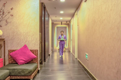 Nurse walking calmly through a peaceful, softly lit hallway in the clinic.