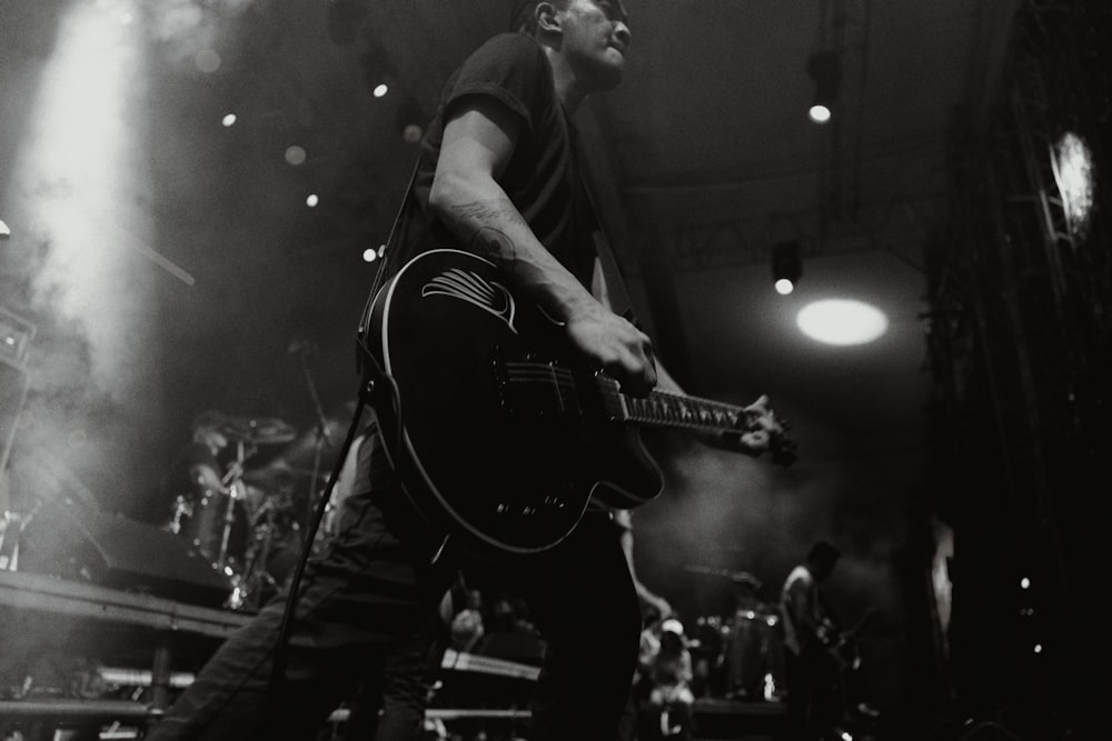 a man playing a guitar on stage at a concert