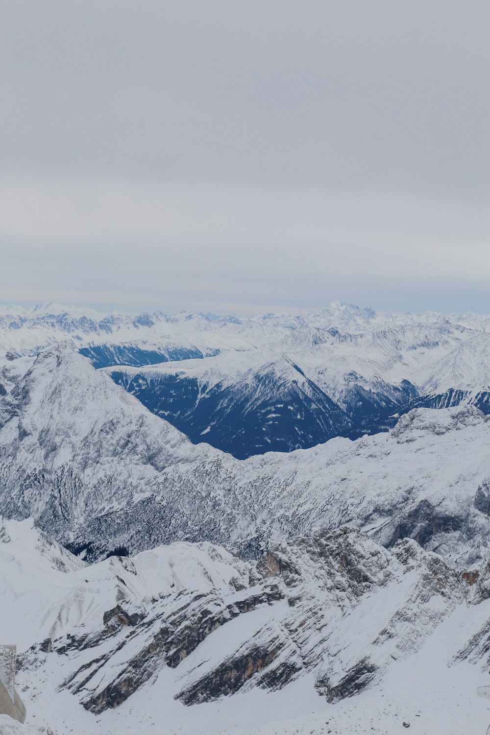 a snowy mountain range with mountains in the distance