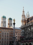 a statue in front of a building with a clock tower in the background