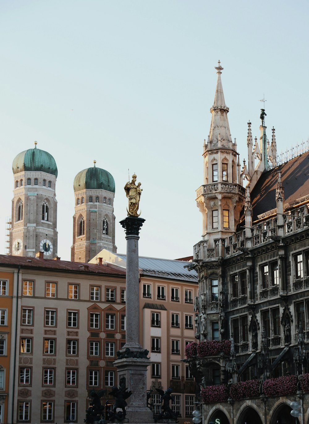 a statue in front of a building with a clock tower in the background