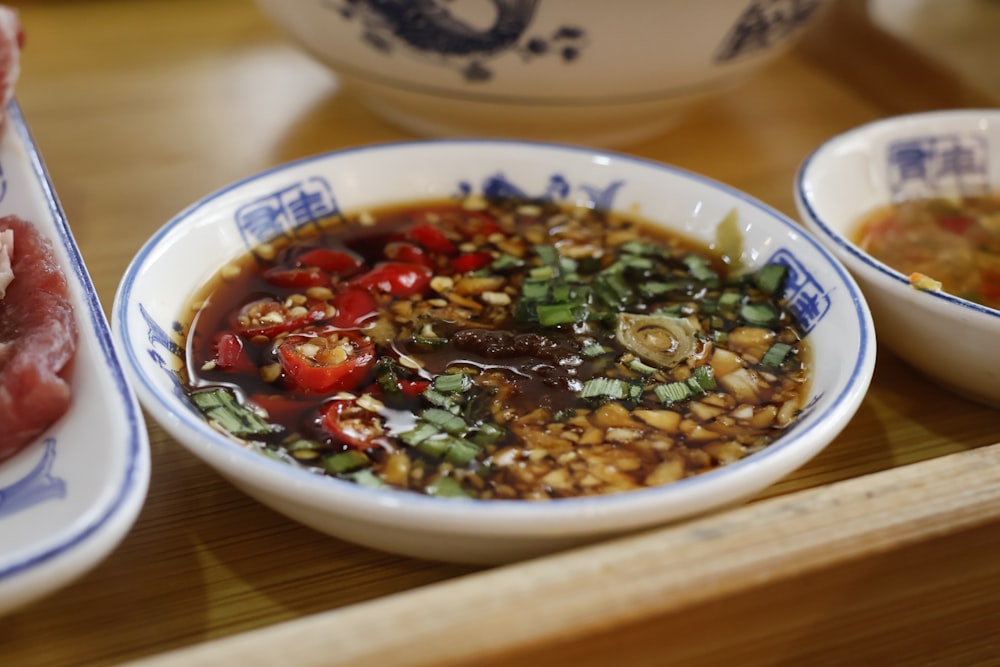 a wooden table topped with bowls of food