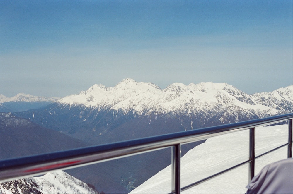 a view of a snowy mountain range from a balcony