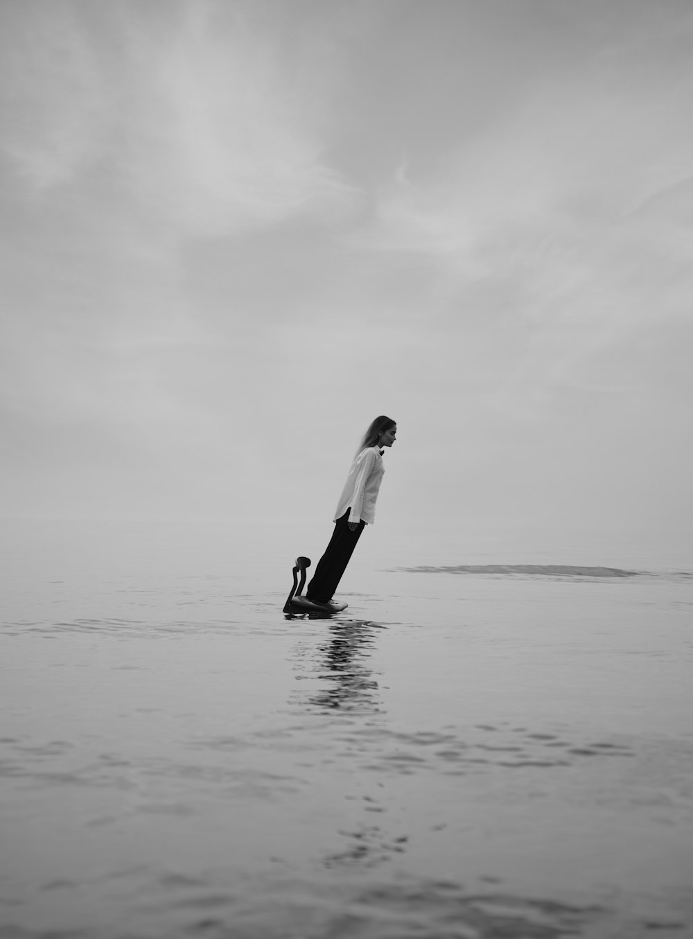 a woman standing on a surfboard in the ocean