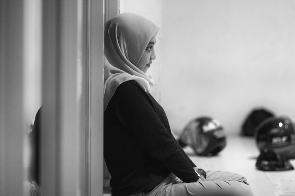 a woman in a hijab is sitting on the floor