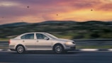 A Kayseri Kartal Taksi car driving smoothly on a highway with scenic hills in the background.