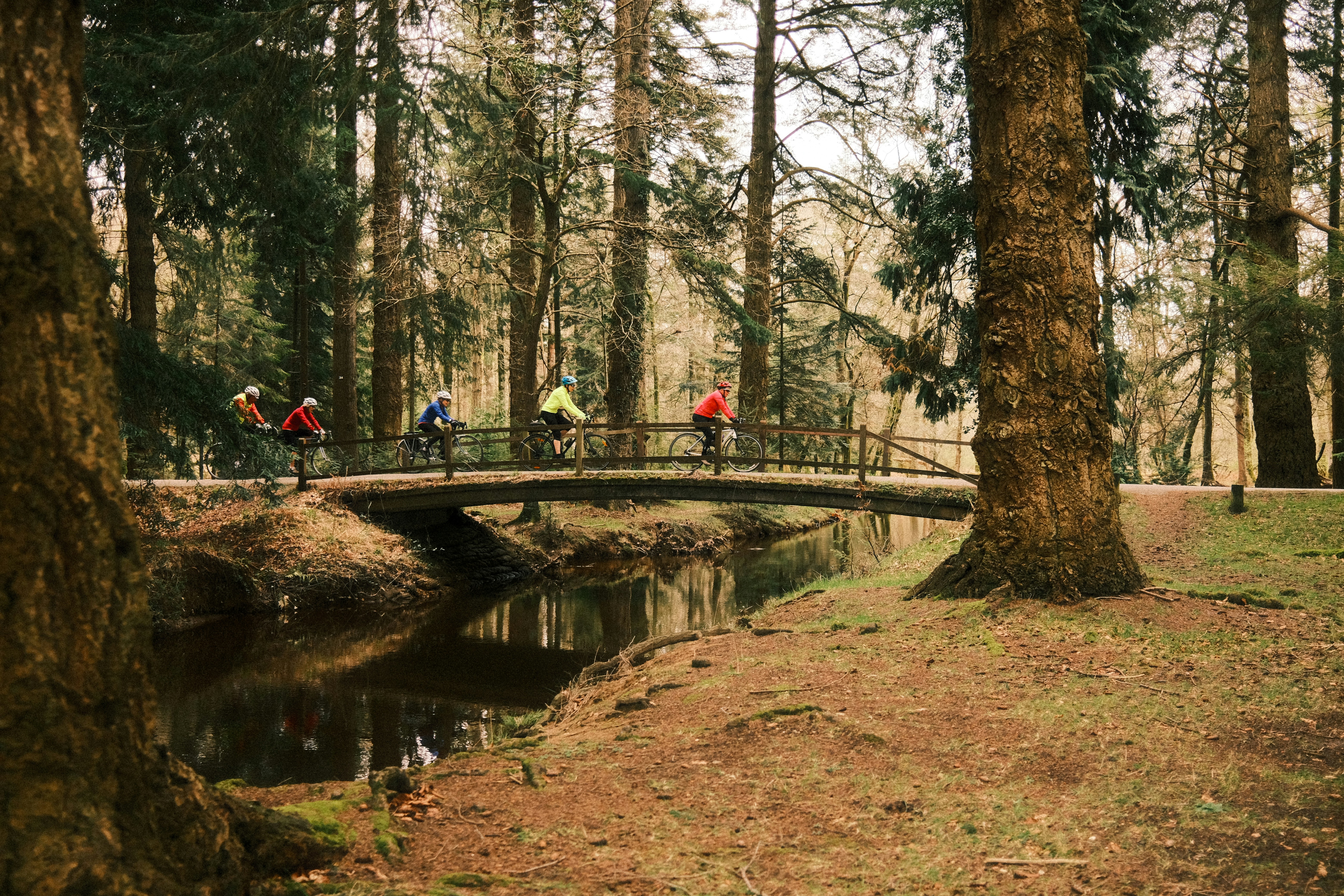 a group of people riding bikes across a bridge
