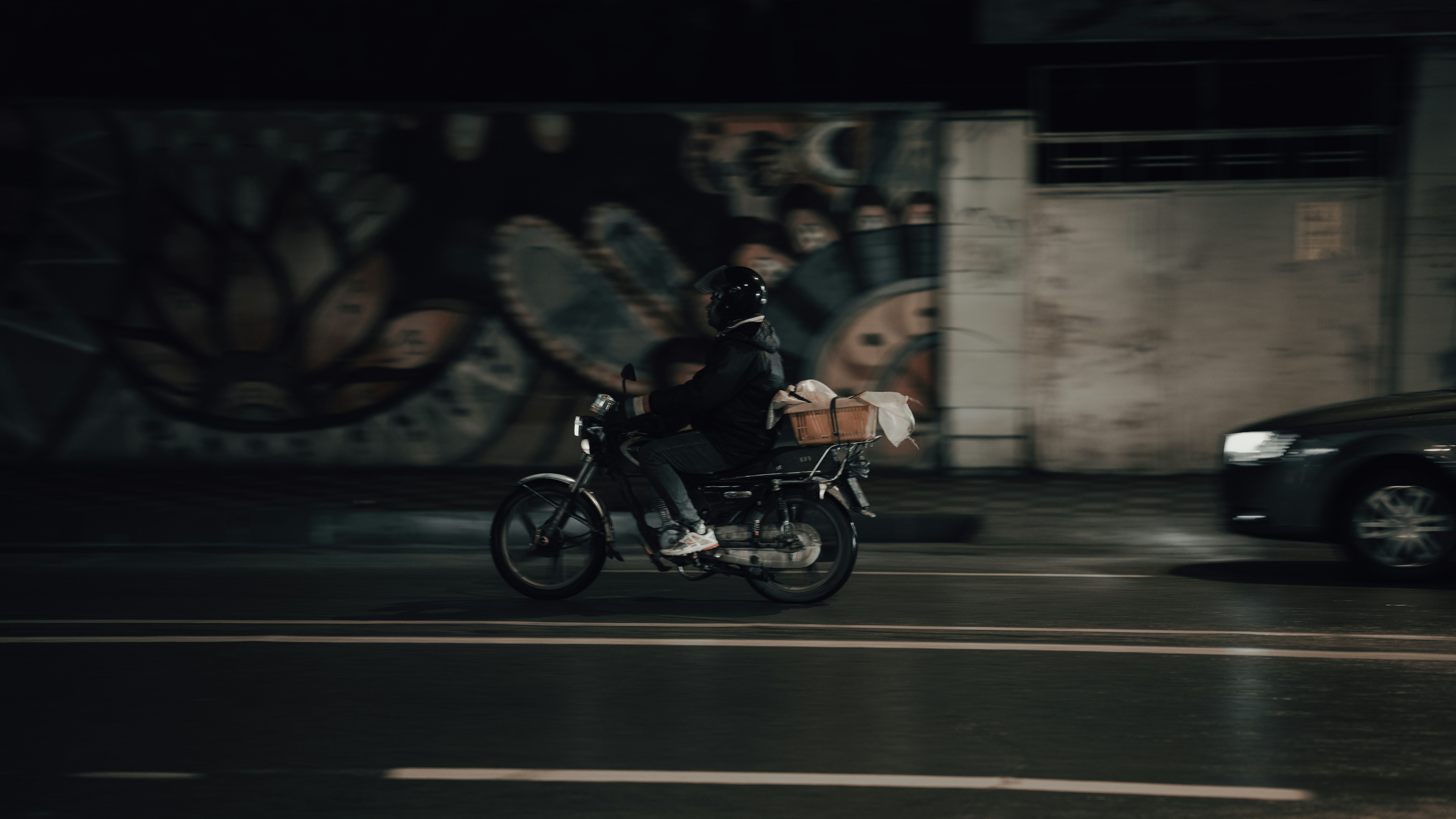 a man riding a motorcycle down a street at night