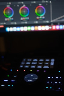 a close up of a keyboard with a computer monitor in the background