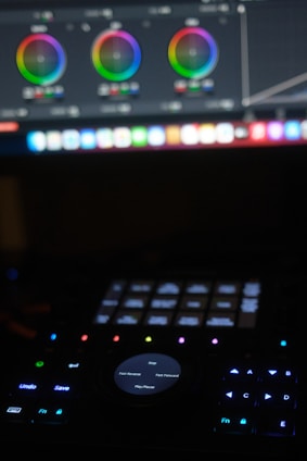 a close up of a keyboard with a computer monitor in the background