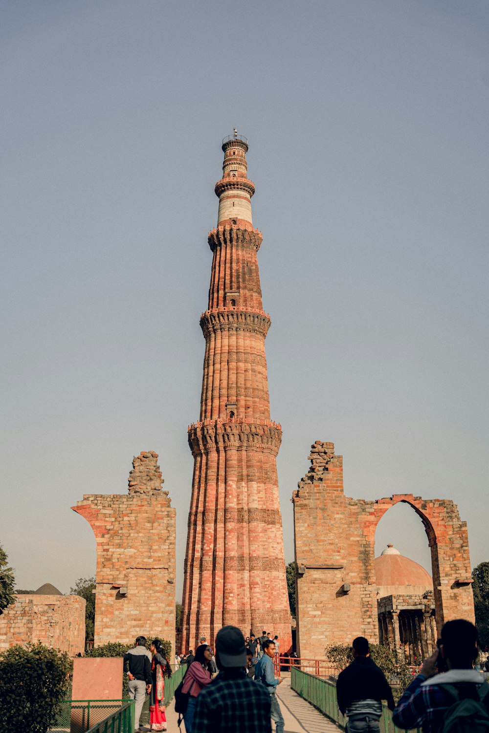 a group of people walking across a bridge next to a tall tower