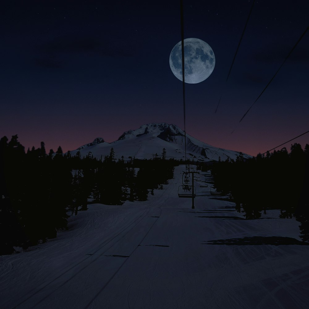 a full moon is seen over a ski slope