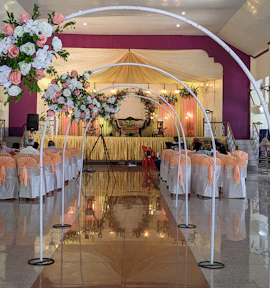 A corporate event setup featuring a professional stage, seating, and ambient lighting at Gangaram Restaurant & Banquet Hall.