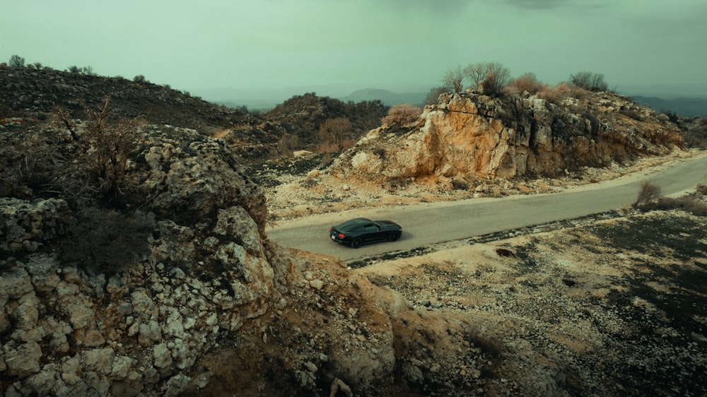 a car driving down a road in the mountains