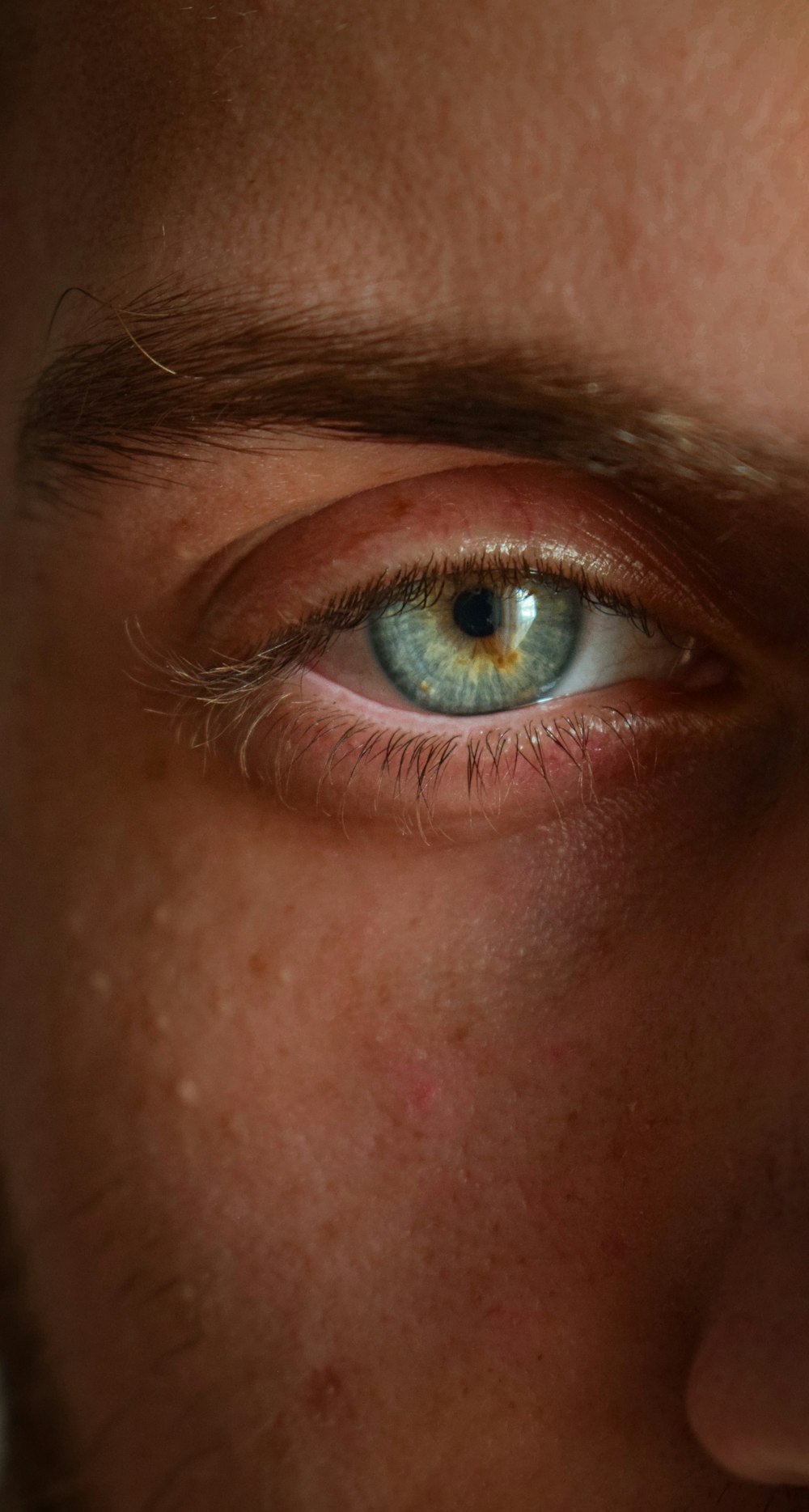 a close up of a person's face with a blue eye