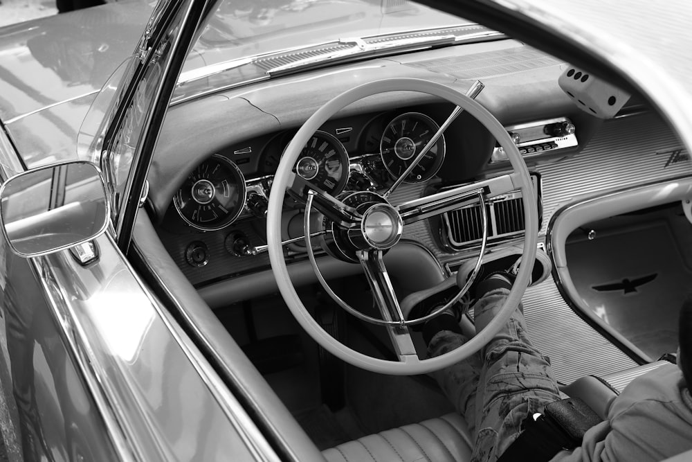 a man sitting in a car with his feet on the steering wheel