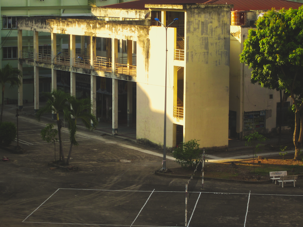 a tennis court in front of a large building