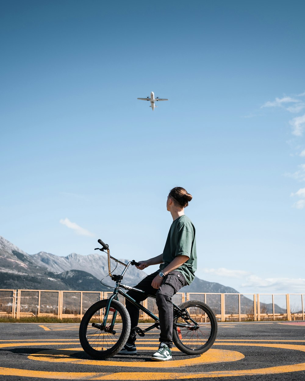 a person sitting on a bike in a parking lot