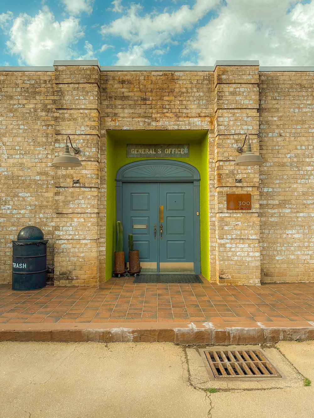 um edifício de tijolos com uma porta azul e uma porta verde