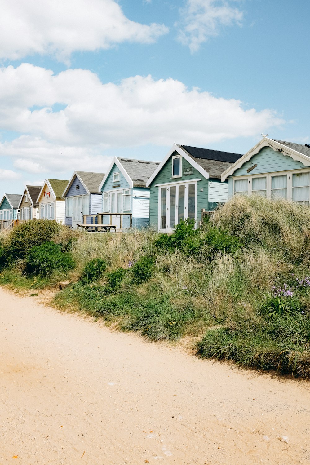 uma fileira de casas de praia em uma praia de areia