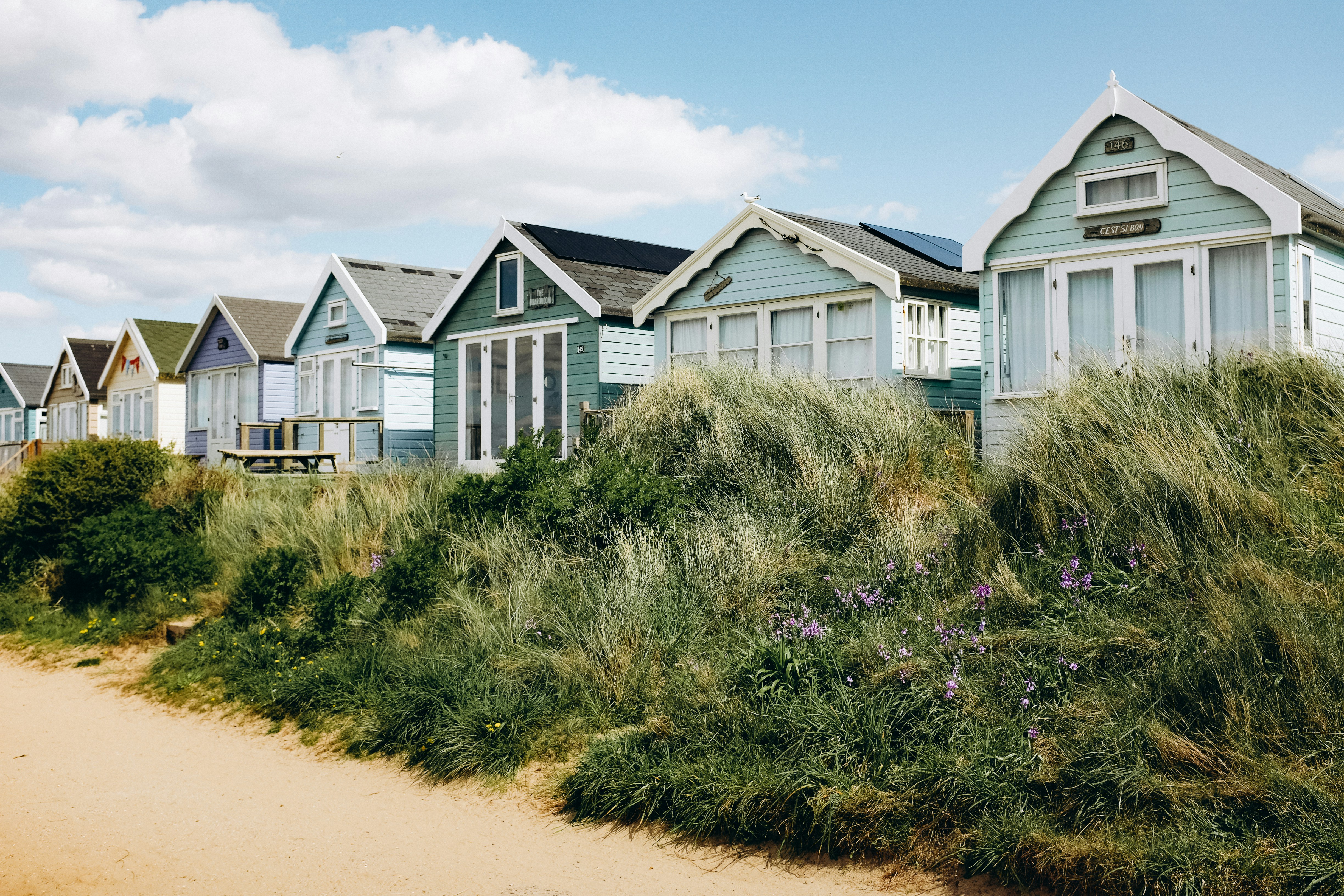 a row of beach houses sitting next to each other, Row of beach huts in Mudeford, Christchurch UK