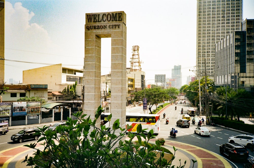 a view of a city street with cars, buses, and people