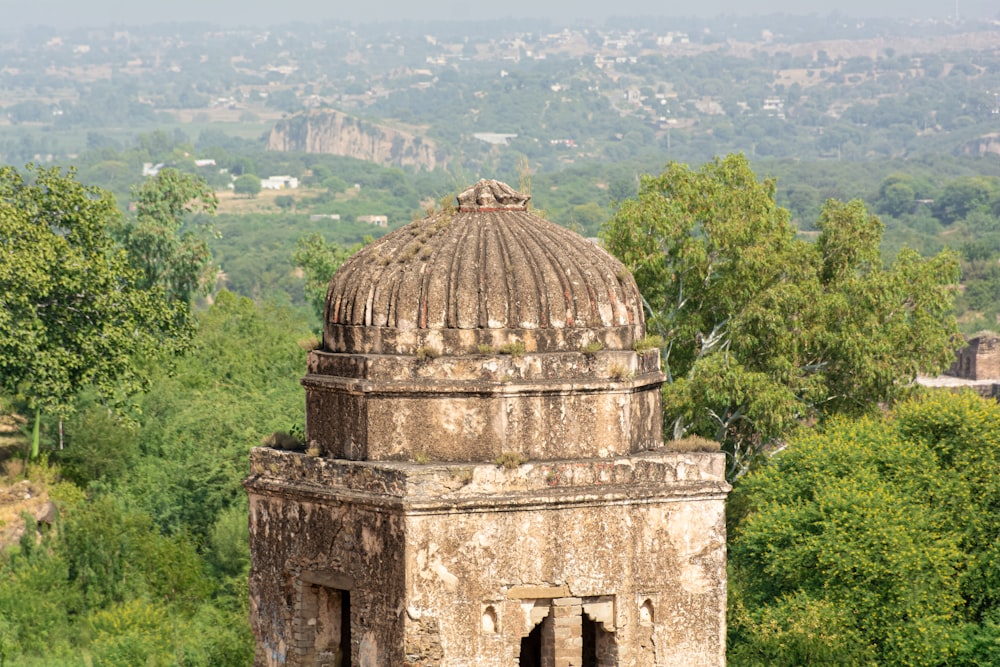 an old building with a dome in the middle of a forest