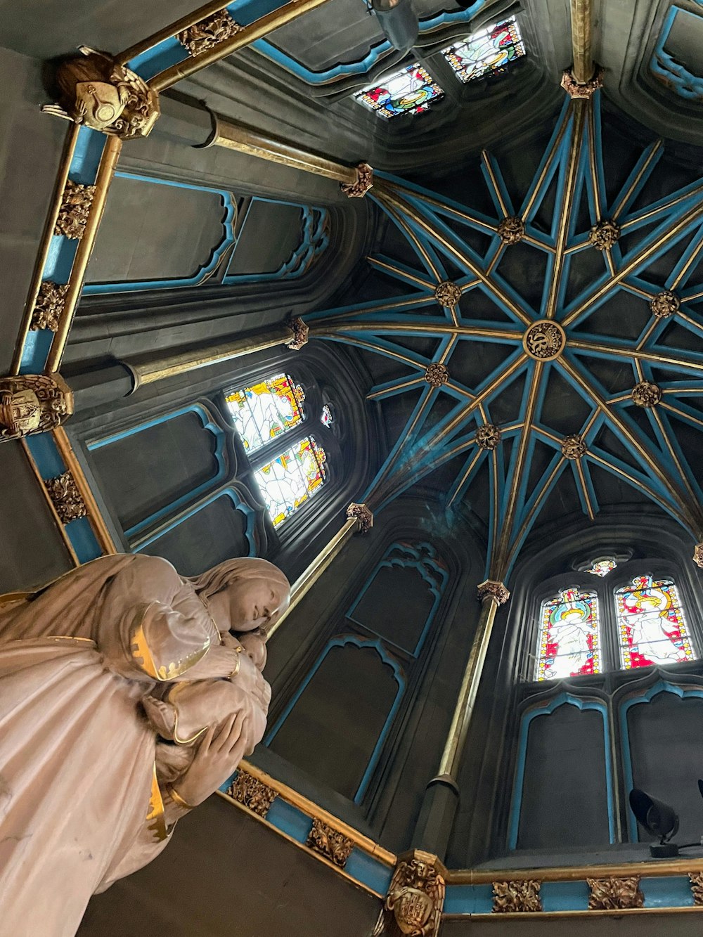 a view of the ceiling of a church with stained glass windows