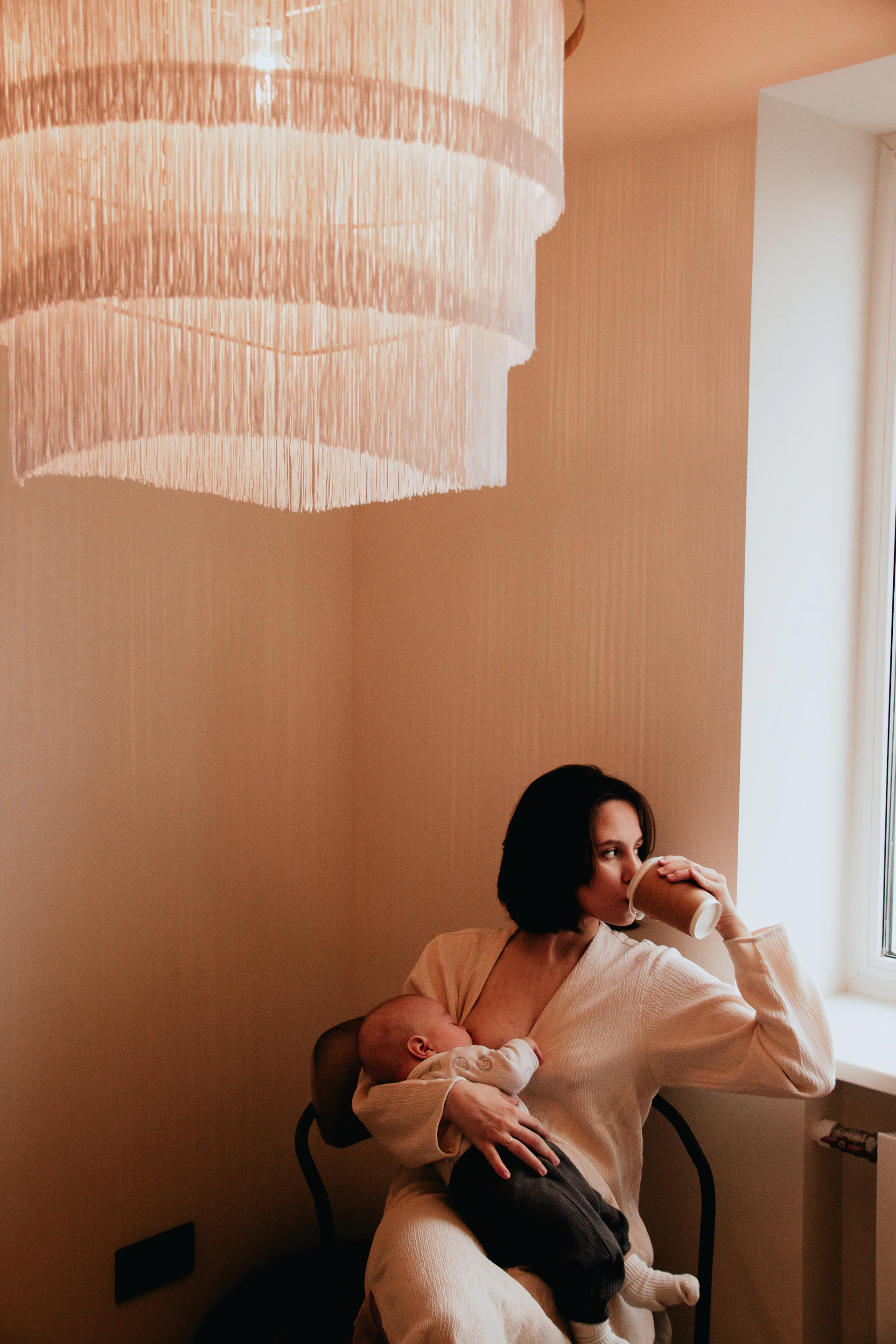a woman sitting in a chair holding a baby