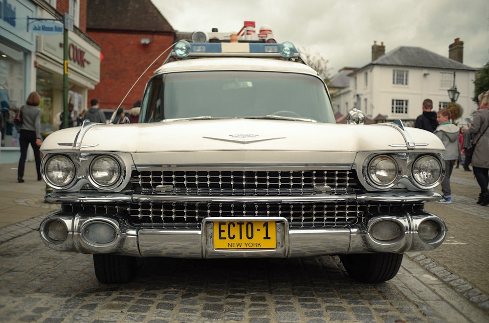 a classic car parked on a cobblestone street