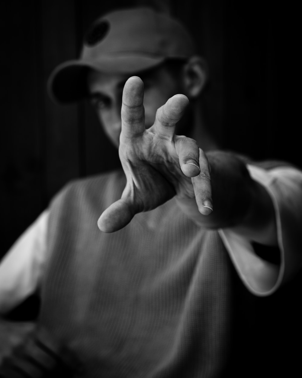 a black and white photo of a man making a hand sign