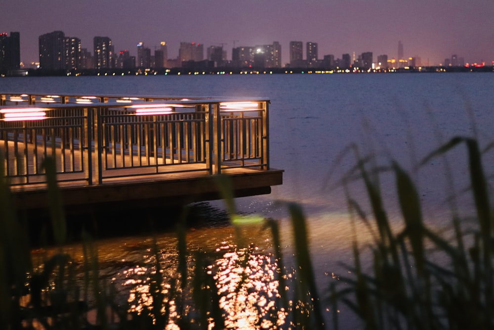 a pier with lights reflecting in the water