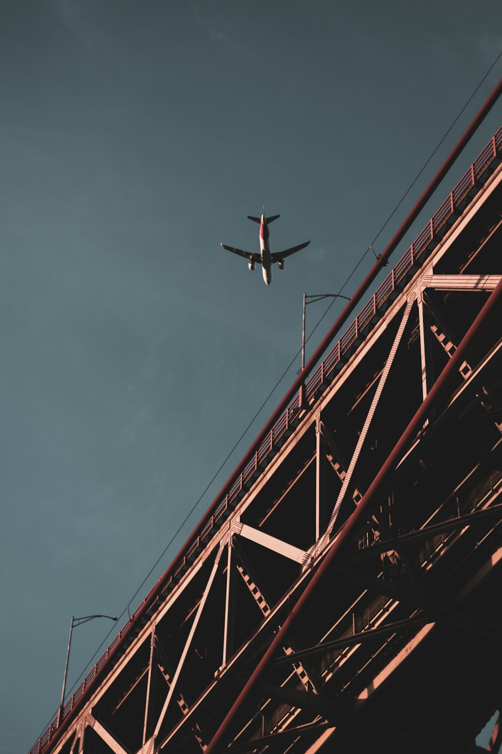 an airplane flying over a bridge on a clear day