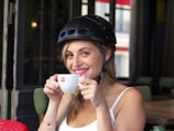 Smiling Go-Jek customer service team member taking a break with a coffee.