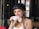 A smiling woman enjoying coffee at a community gathering.