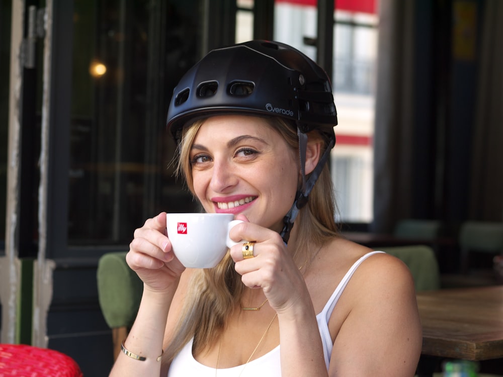 Une femme portant un casque buvant une tasse de café