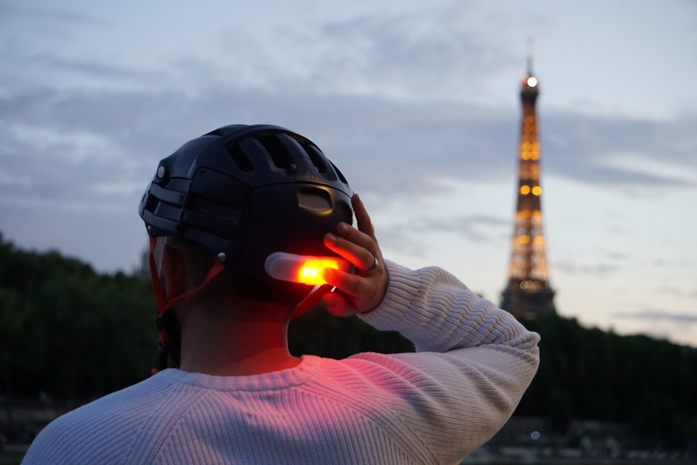 Un homme portant un casque avec la Tour Eiffel en arrière-plan