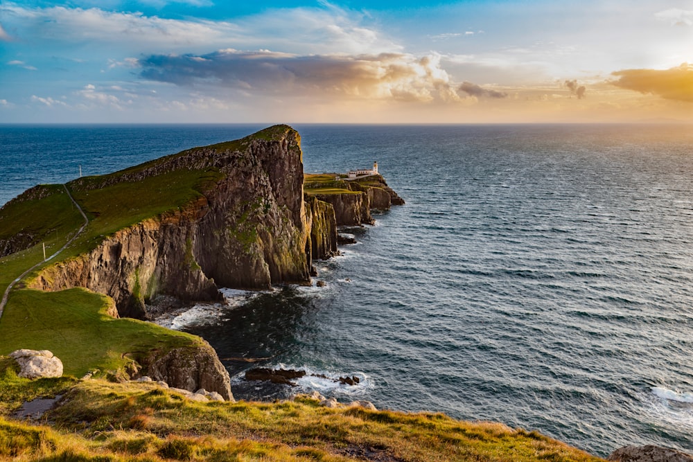 a large body of water next to a rocky cliff