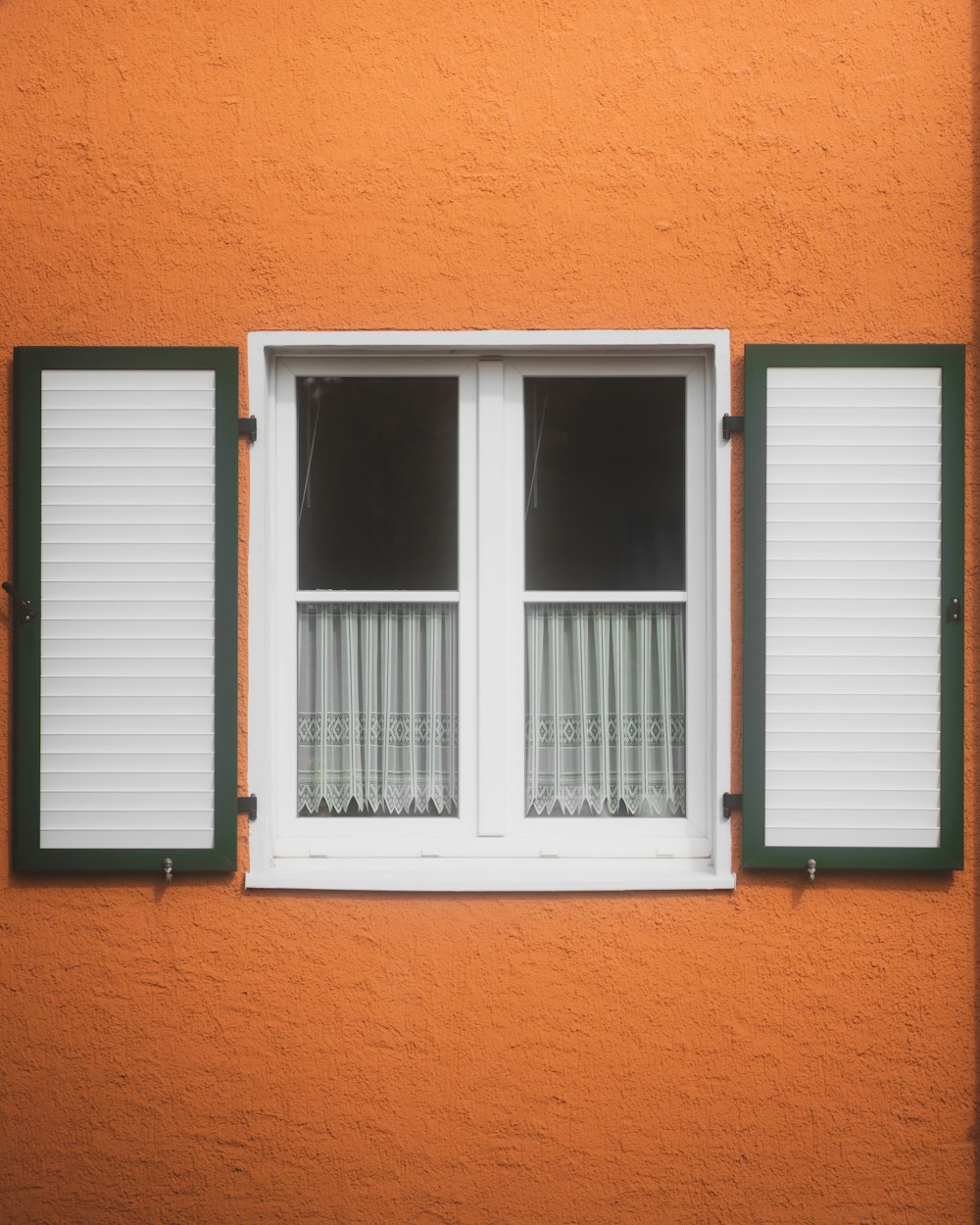 a close up of a window with green shutters