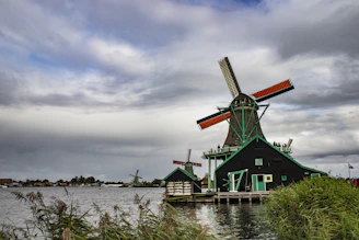 a windmill sitting next to a body of water