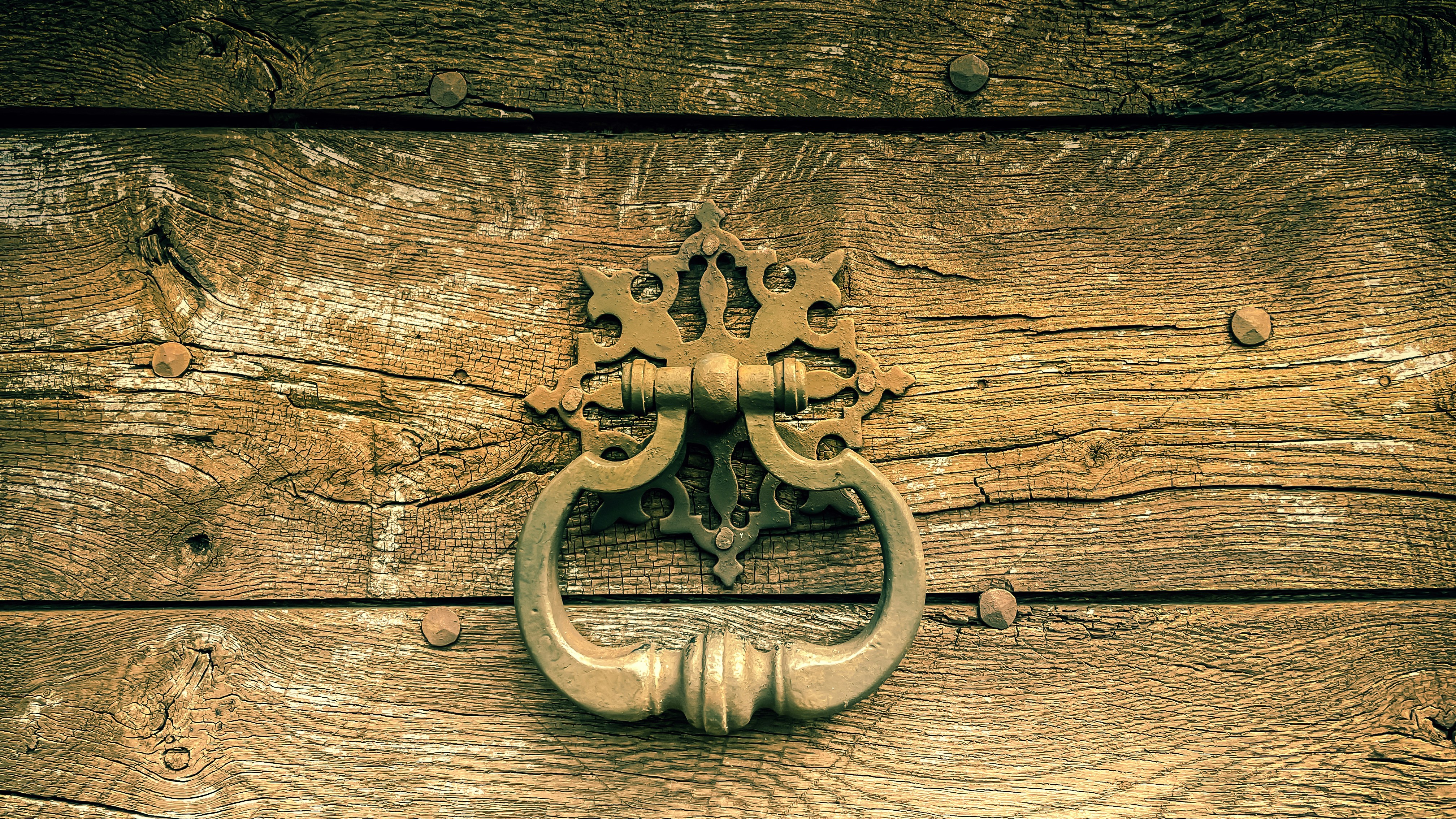 a close up of a door handle on a wooden door