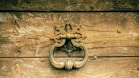 a close up of a door handle on a wooden door