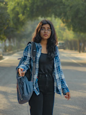 a woman walking down a street holding a handbag