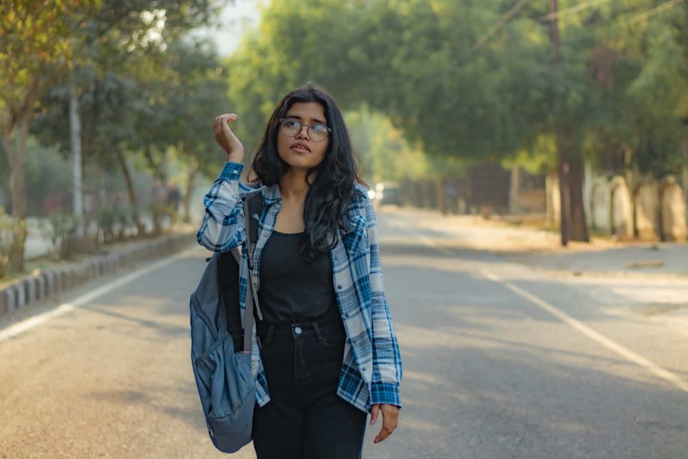 a woman walking down a street with a backpack