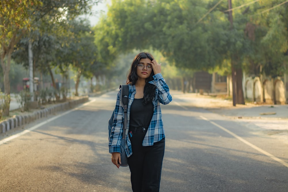 a woman walking down a street while talking on a cell phone